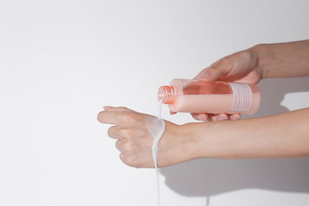producto de belleza siendo vertido en la mano de una modelo